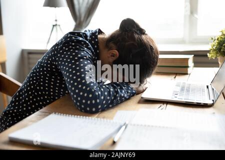 Fatigué indian girl student sleeping at desk épuisé après l'apprentissage Banque D'Images