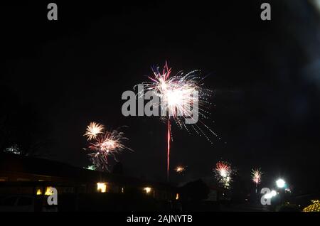 La nouvelle année firewrok vu plus d'une colonie ou semi-rural dans la nuit. Banque D'Images