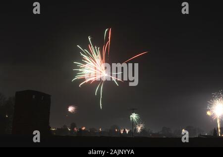 La nouvelle année firewrok vu plus d'une colonie ou semi-rural dans la nuit. Banque D'Images