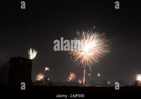 La nouvelle année firewrok vu plus d'une colonie ou semi-rural dans la nuit. Banque D'Images