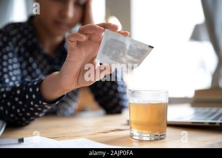 Femme malade pour la poudre du médicament dans un verre de soulager les symptômes de la grippe Banque D'Images