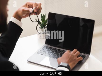 Portrait of African businessman using laptop avec écran vide, plate-forme d'affaires Banque D'Images