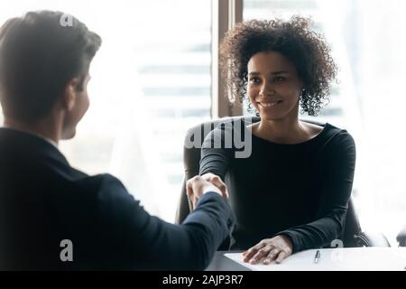 Smiling businesswoman biracial handshake fermer traiter avec collègue masculin Banque D'Images