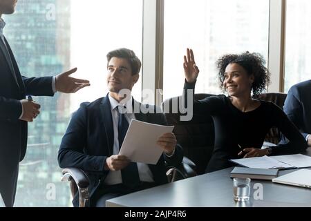 African American female employé à lever la main de la réunion de l'équipe Banque D'Images