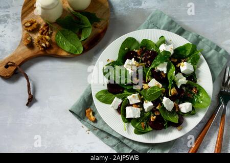 Snack-vitamine. Salade d'épinards, fromage feta, betterave et noix, huile végétale sauceon une table en béton. Copier l'espace. Banque D'Images