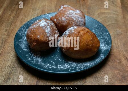 Donut traditionnel néerlandais sur une assiette, avec du sucre en poudre sur elle. Appelé oliebollen aux Pays-Bas. Surtout mangé le soir du Nouvel An Banque D'Images