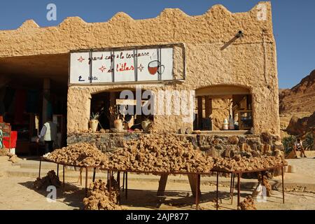 L'Atlas, le grand café avec une terrasse à l'entrée de Chebika oasis. Sur la table il y a à vendre Roses du Sahara Occidental Banque D'Images