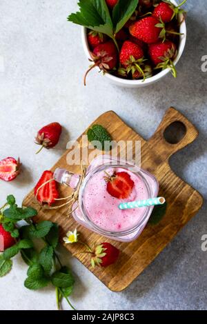Yaourt aux fruits fraise smoothie ou milk shake dans un bocal en verre sur une table en bois. Désintoxication naturelle, fruits dessert, suivre un régime sain concept. Vue de dessus la télévision Banque D'Images