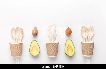 Sauver l'environnement. Vaisselle en plastique Eco tasse en bois avec de l'avocat les graines sur fond blanc, copy space Banque D'Images