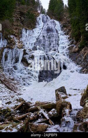 Paysage d'hiver avec cascade de montagne sur les bords gelés Banque D'Images