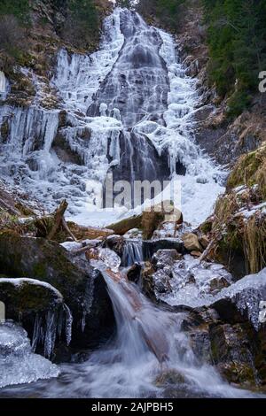 Paysage d'hiver avec cascade de montagne sur les bords gelés Banque D'Images