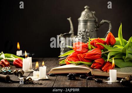 Tulipes orange sur le vieux livre Banque D'Images