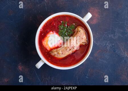 Vue de dessus de la betterave et soupe de tomate avec la crème sure et côtes de boeuf Banque D'Images