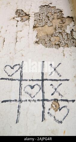 Jeu Simple - X-O jeu. Hand drawn tic-tac-toe éléments. L'amour de plomb sur vieux mur fissuré. Banque D'Images