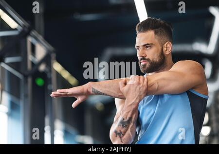 L'échauffement. Sportsman étend ses mains avant la formation d'entraînement au gymnase, libre, l'espace libre Banque D'Images