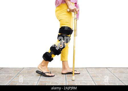 Femme jambe dans une orthèse en se tenant debout sur le plancher isolé. Banque D'Images