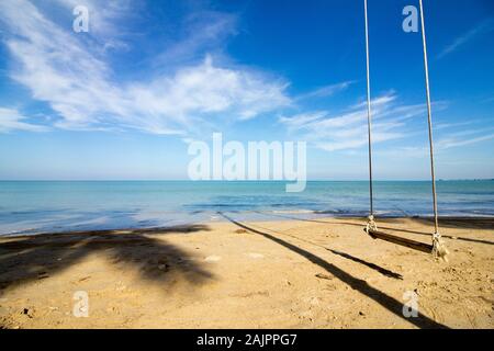 Lonely swing sur une plage de rêve en face d'une mer turquoise céleste Banque D'Images