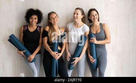 Portrait de groupe avec femmes sportive diversifiée sourire tapis de yoga Banque D'Images