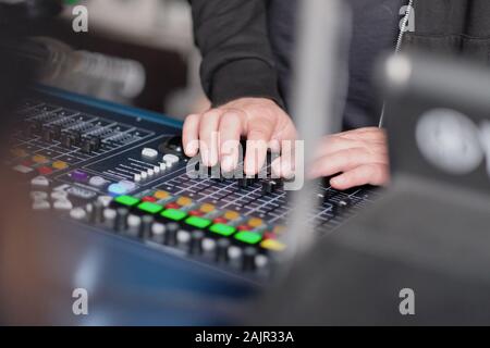 Les mains de l'ingénieur du son sur la console de mixage pendant le concert Banque D'Images