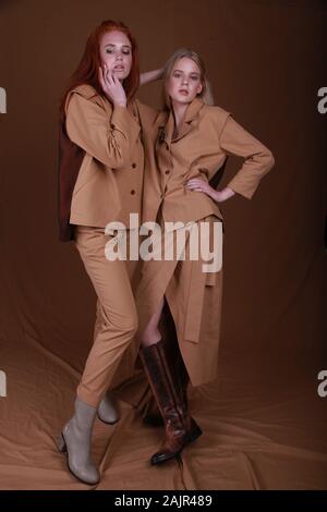 Sœurs dans le quartier branché de vêtements de créateurs, mathcing le style et la couleur beige sur fond de studio. Sœur enchanteur ami, mode beauté concept/pleine longueur Banque D'Images