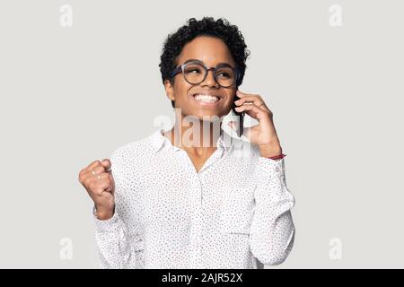 African Woman talking on cellphone heureux d'entendre de bonnes nouvelles Banque D'Images