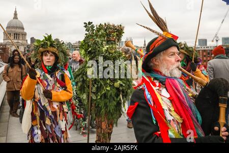 Londres, Royaume-Uni. 5e jan 2020. The Holly Man sur le pont du Millénaire. 25e congrès annuel de la Douzième Nuit de fête, une ancienne coutume de l'hiver, est tenue à Bankside, effectuée par la partie 'Lions' joueurs. L'homme, en bois de houx feuillage vert, est joué sur la Tamise. Il est rejoint par la London les mimes, de toasts (wassail) le peuple, et effectuer de combat folk freestyle jouer en costumes colorés. La procession se déplace de l'autre côté de la rivière, à Shakespeare's Globe et à la St George Inn, Southwark. Credit : Imageplotter/Alamy Live News Banque D'Images