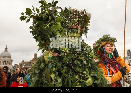 Londres, Royaume-Uni. 5e jan 2020. The Holly Man sur le pont du Millénaire. 25e congrès annuel de la Douzième Nuit de fête, une ancienne coutume de l'hiver, est tenue à Bankside, effectuée par la partie 'Lions' joueurs. L'homme, en bois de houx feuillage vert, est joué sur la Tamise. Il est rejoint par la London les mimes, de toasts (wassail) le peuple, et effectuer de combat folk freestyle jouer en costumes colorés. La procession se déplace de l'autre côté de la rivière, à Shakespeare's Globe et à la St George Inn, Southwark. Credit : Imageplotter/Alamy Live News Banque D'Images