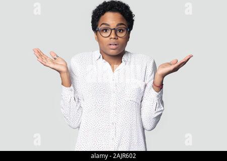 Femme africaine confus haussa les épaules soulevées palms studio shot Banque D'Images