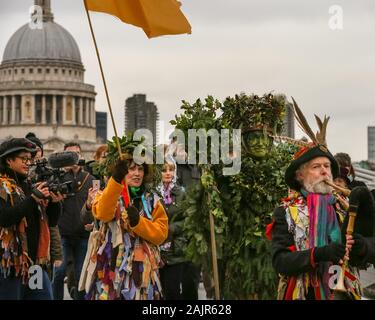 Londres, Royaume-Uni. 5e jan 2020. The Holly Man sur le pont du Millénaire. 25e congrès annuel de la Douzième Nuit de fête, une ancienne coutume de l'hiver, est tenue à Bankside, effectuée par la partie 'Lions' joueurs. L'homme, en bois de houx feuillage vert, est joué sur la Tamise. Il est rejoint par la London les mimes, de toasts (wassail) le peuple, et effectuer de combat folk freestyle jouer en costumes colorés. La procession se déplace de l'autre côté de la rivière, à Shakespeare's Globe et à la St George Inn, Southwark. Credit : Imageplotter/Alamy Live News Banque D'Images