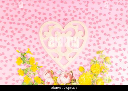 Décoration en forme de coeur en bois avec des fleurs en papier 3D sur un fond rose Banque D'Images