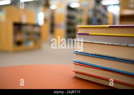 Pile de livres sur une table en bois dans une bibliothèque Banque D'Images