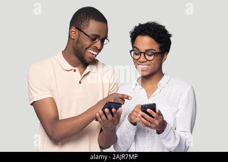 African couple tenir avoir smartphones in internet studio shot Banque D'Images