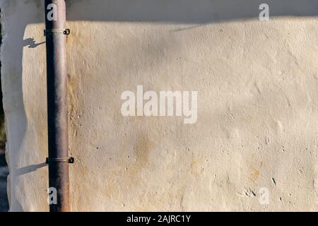 Gouttière sur un mur d'une maison. Banque D'Images