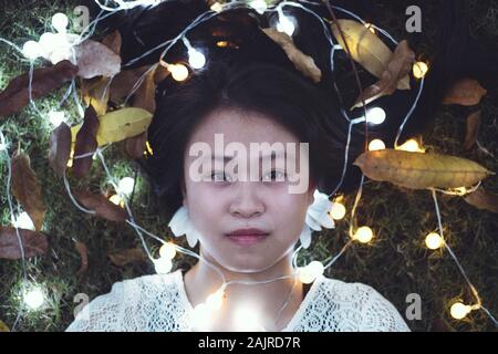 Portrait de belles filles asiatiques meilleurs amis allongé sur lumières colorées sur l'herbe - Très beau modèle de mode des femmes vietnamiennes Banque D'Images