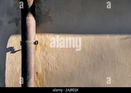 Gouttière sur un mur d'une maison. Banque D'Images