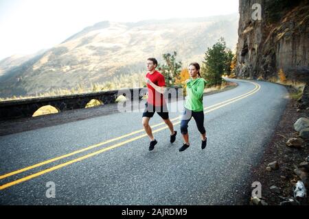 Deux coureurs dans leur milieu de la vingtaine en courant le long de la route pittoresque à Rowena Banque D'Images