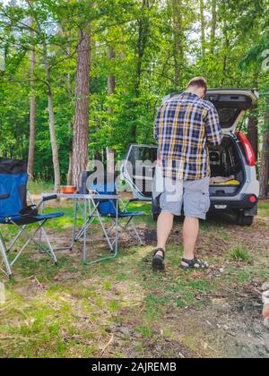 Homme marchant à voiture suv concept camping Banque D'Images