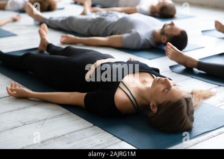 Belle femme méditant dans Savasana posent près, la pratique du yoga Banque D'Images