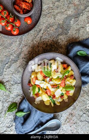 Gnocchi à faible teneur en calories de la salade de pâtes avec de la vapeur et épinards, tomates séchées au soleil et parmesan Banque D'Images