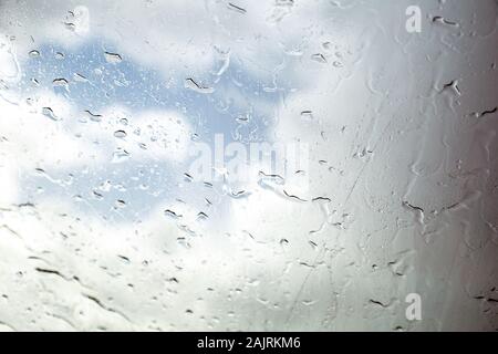 Vitre de voiture avec gouttes de pluie. Conduite sous la pluie. Contexte météo. Verre pluvieux. Banque D'Images