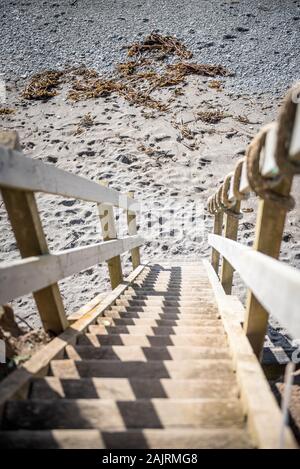 Escalier en bois menant à une plage de sable de Downderry, Cornwall, Royaume-Uni Banque D'Images