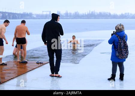 Sports d'hiver, le trempage. Les gens se lever et nager dans l'hiver dans le trou dans la glace sur le fleuve Dniepr au cours de la maison de l'Epiphanie orthodoxe. Ville de Dnipro Banque D'Images