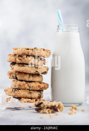 Biscuits bio faits maison avec des raisins et des abricots et bouteille de lait sur la lumière d'arrière-plan de cuisine. Banque D'Images