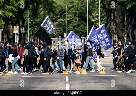 Hong Kong, Chine. 05Th Jan, 2020. Personnes brandissant le drapeau de protestation "Librate Hong Kong, révolution notre temps' et 'noir' Indépendance Hong Kong en bleu fag de traverser la rue. Un dimanche à Sheung Shui contre le commerce parallèle qui visent à inciter les autorités à prendre des mesures à l'encontre des opérateurs parallèles qui de stock dans les boutiques locales puis tourner autour de les vendre pour le profit de l'autre côté de la frontière. Plus de cette marche de protestation depuis Hong Kong a commencé en juin et ressemblent souvent à un rassemblement anti-gouvernement. Credit : Geisler-Fotopress GmbH/Alamy Live News Banque D'Images