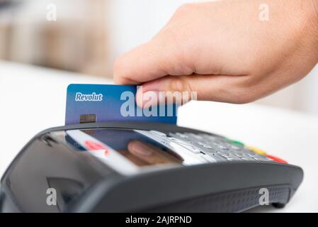 Wroclaw, Pologne - NOV 06, 2019 : le passage de la carte de débit Revolut en terminal de paiement. Revolut UK Ltd est une société de technologie financière offre d'avion ser Banque D'Images