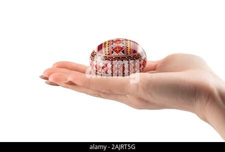 Oeuf de Pâques dans la main femme sur fond blanc Banque D'Images