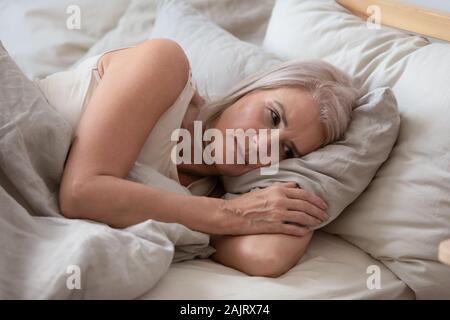 Personnes âgées malheureuse pensée woman Lying in Bed Banque D'Images