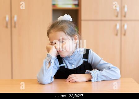 Petite fille dans une robe d'été, passe à côté de son bureau. Banque D'Images