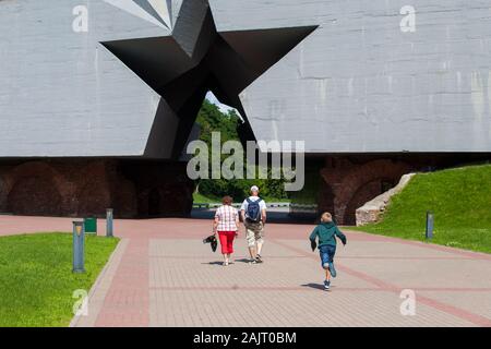 Les familles traversent l'entrée principale du Mémorial de Brest, une étoile coupée en un énorme bloc de béton. Biélorussie Banque D'Images