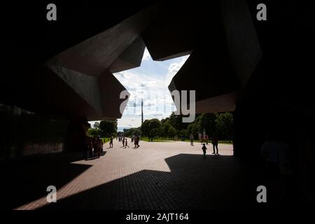 Les familles traversent l'entrée principale du Mémorial de Brest, une étoile coupée en un énorme bloc de béton. Biélorussie Banque D'Images